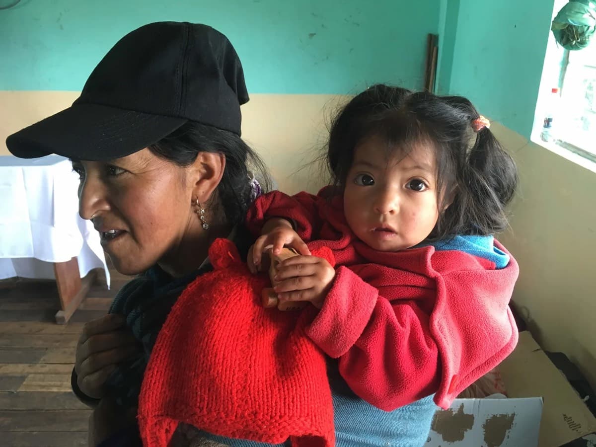 A mother holds her young child at the clinic