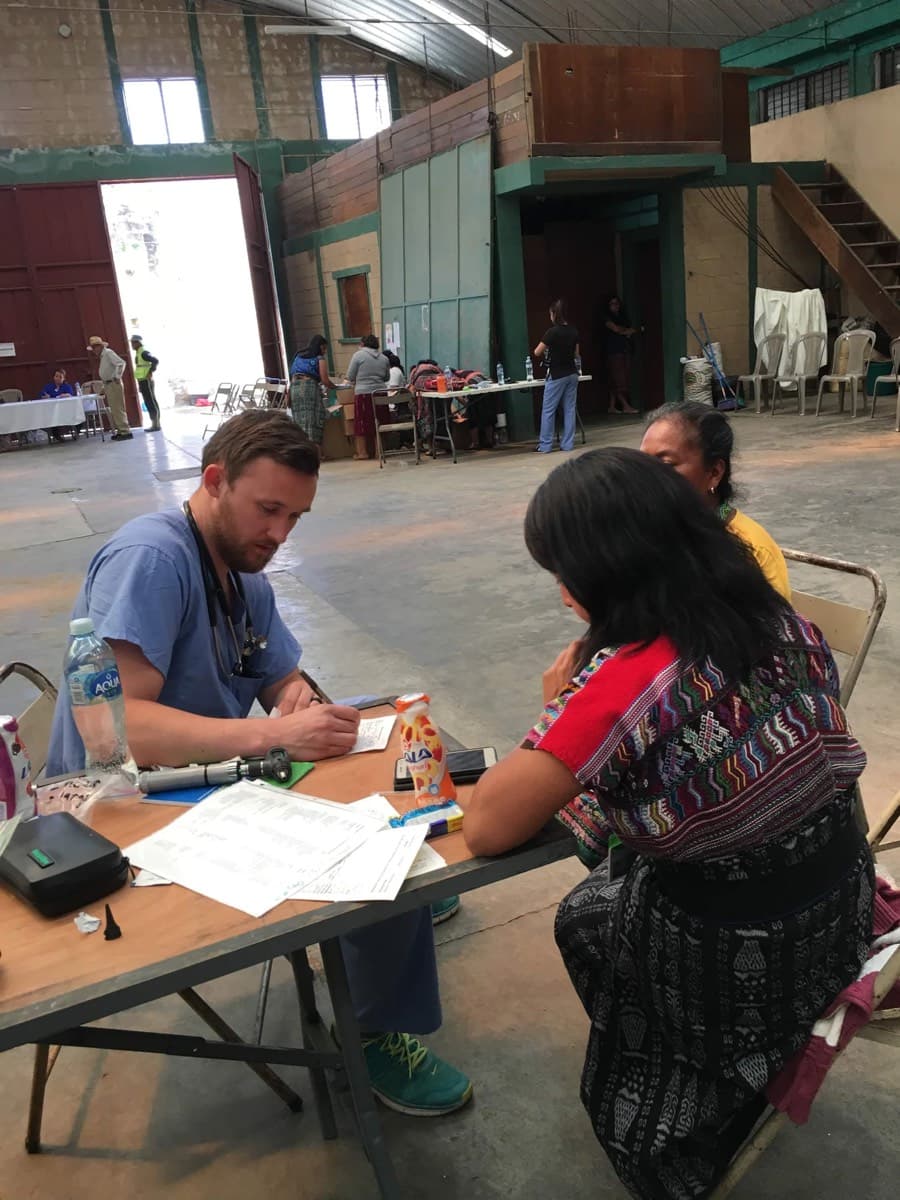A clinician takes a patient's history at the intake table