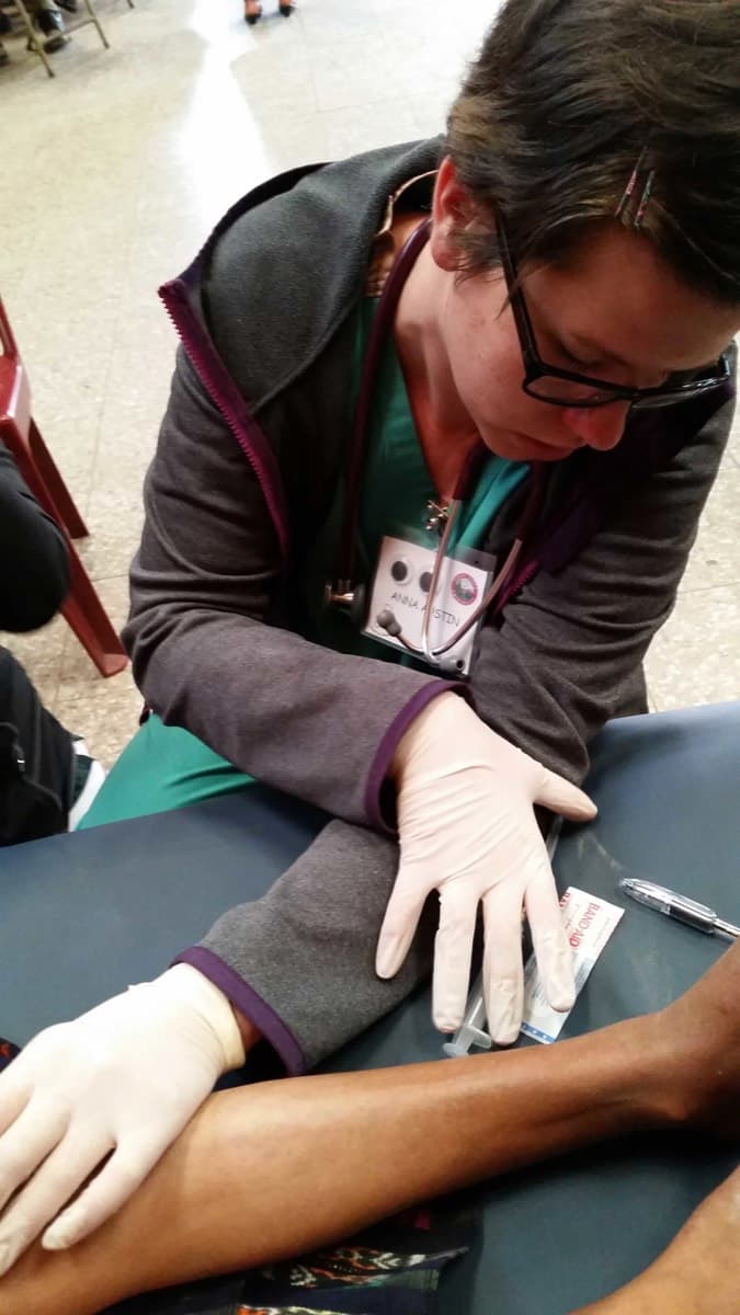 A clinician's gloved hands preparing an instrument during a procedure