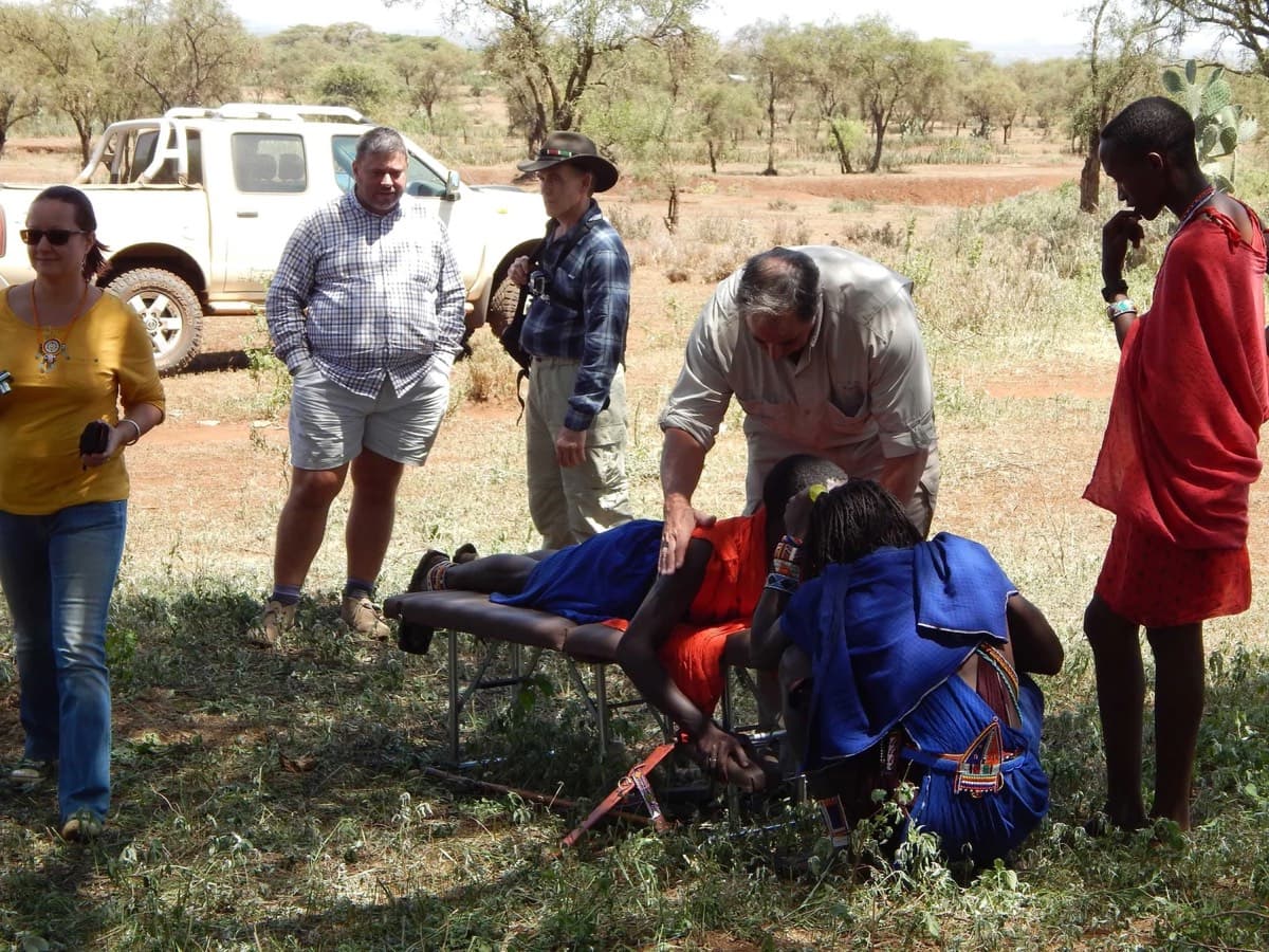 The team helping a patient onto a mat for examination