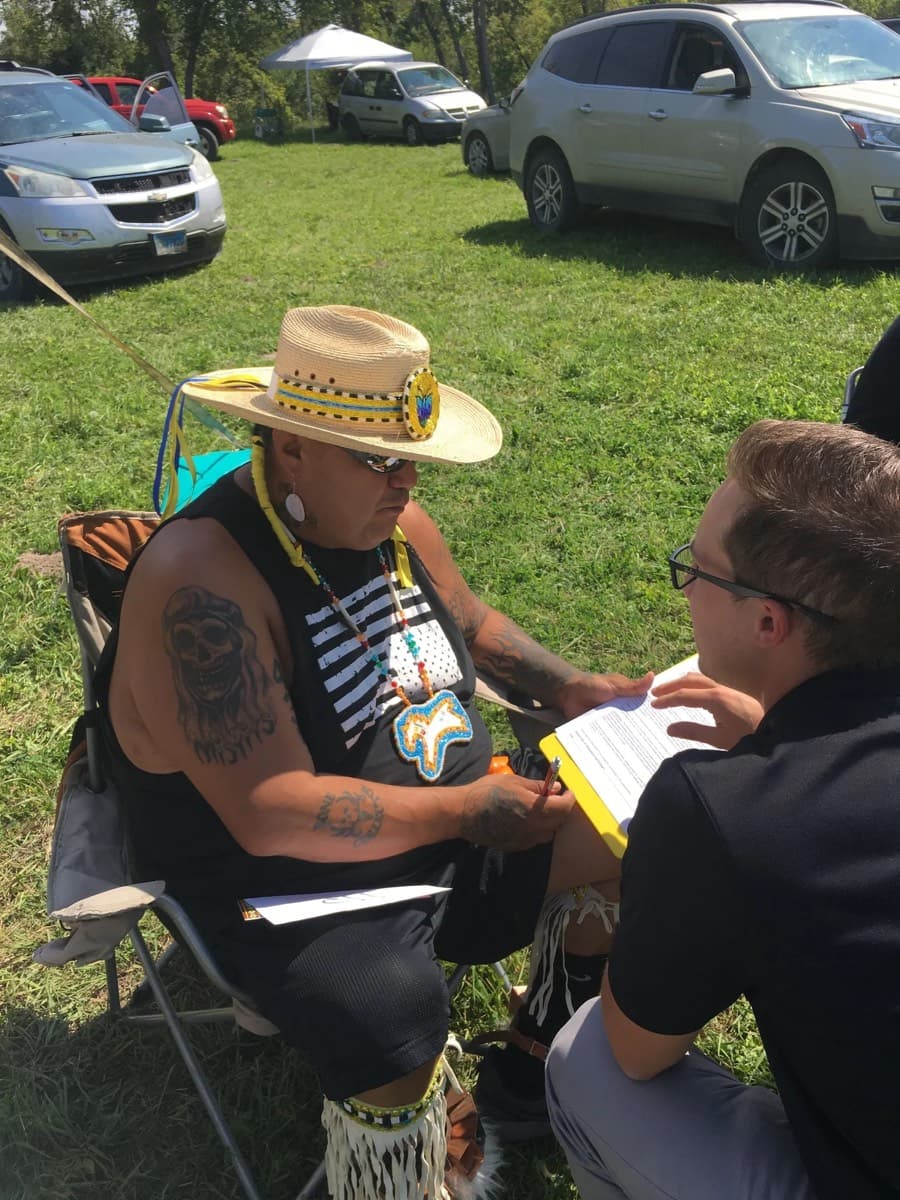 A clinician taking a patient's details at an outdoor table
