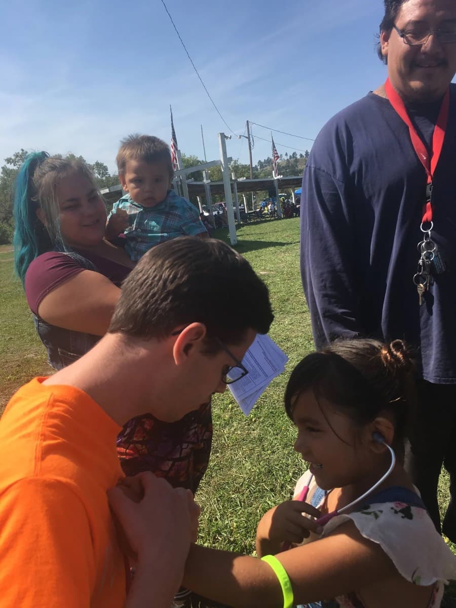 A student clinician checking a young patient